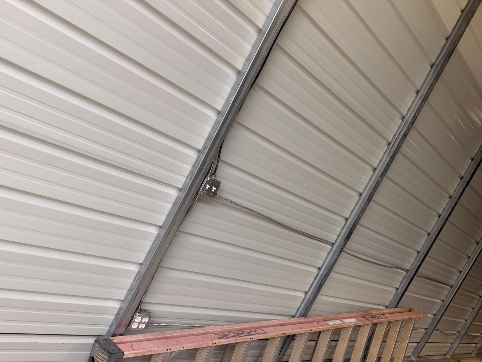 Surface-run conduit and receptacles along the frame of a metal building